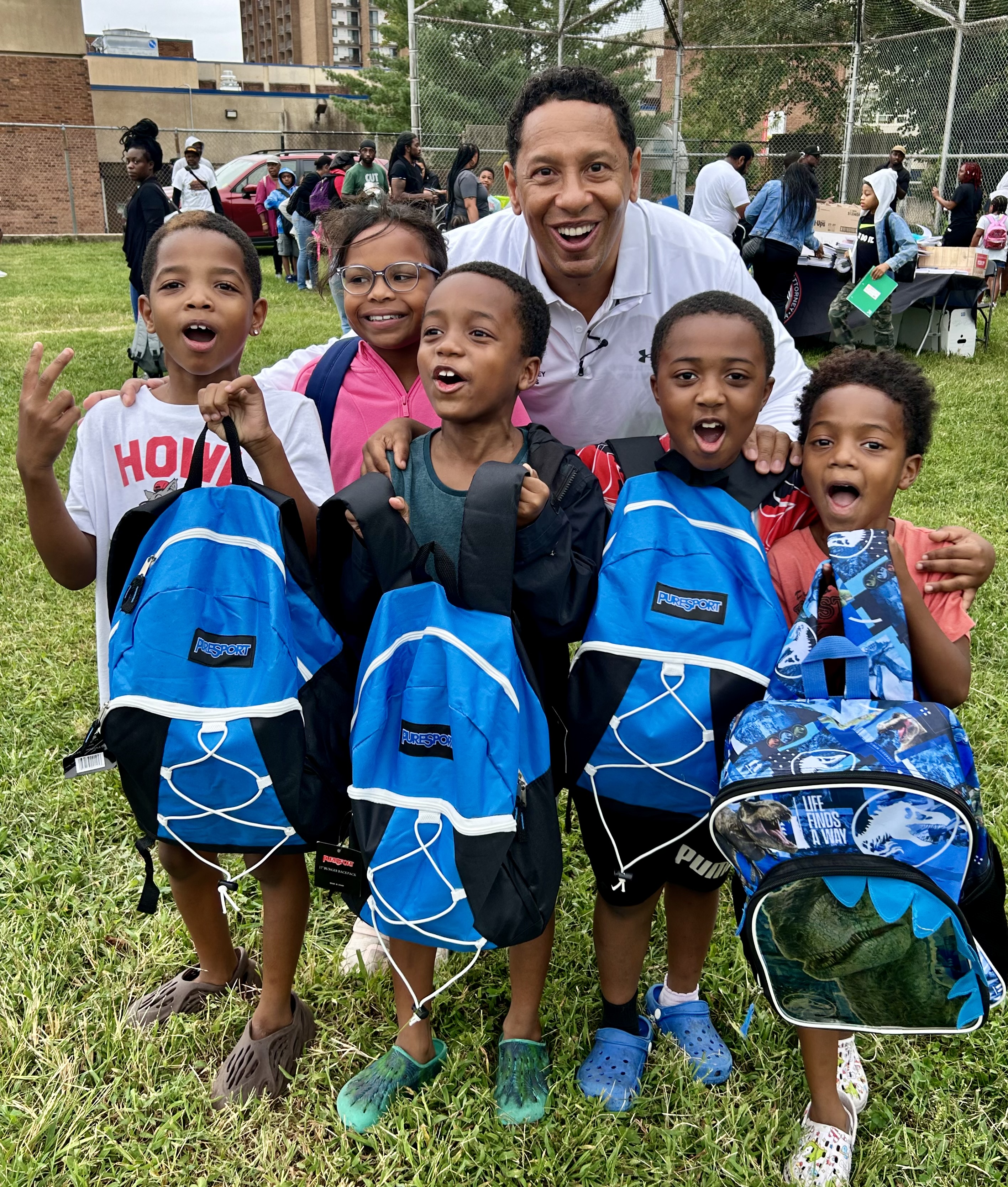 Group of kids holding backpacks with the State's Attorney 