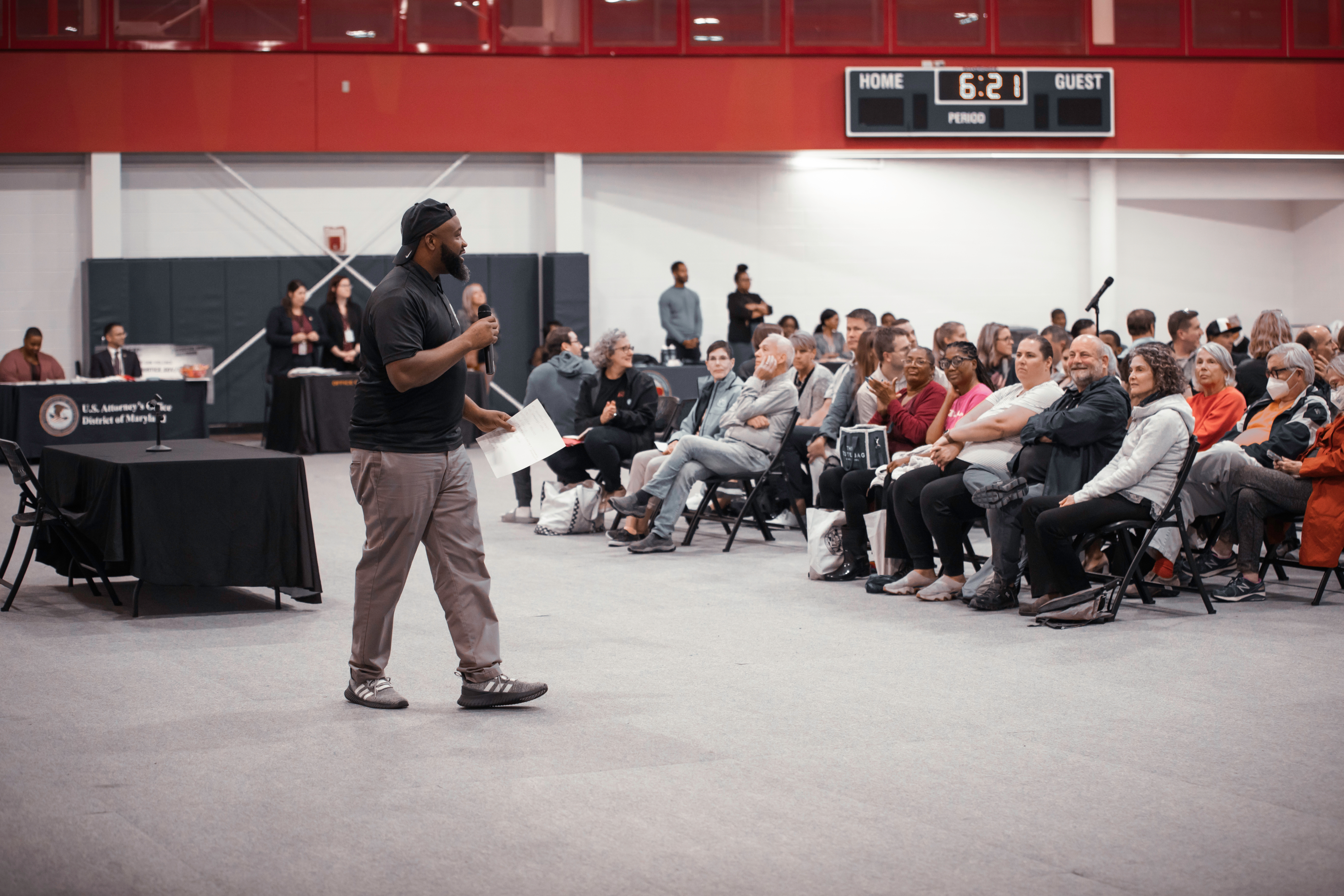 Community meeting attendees gathered in a gymnasium.