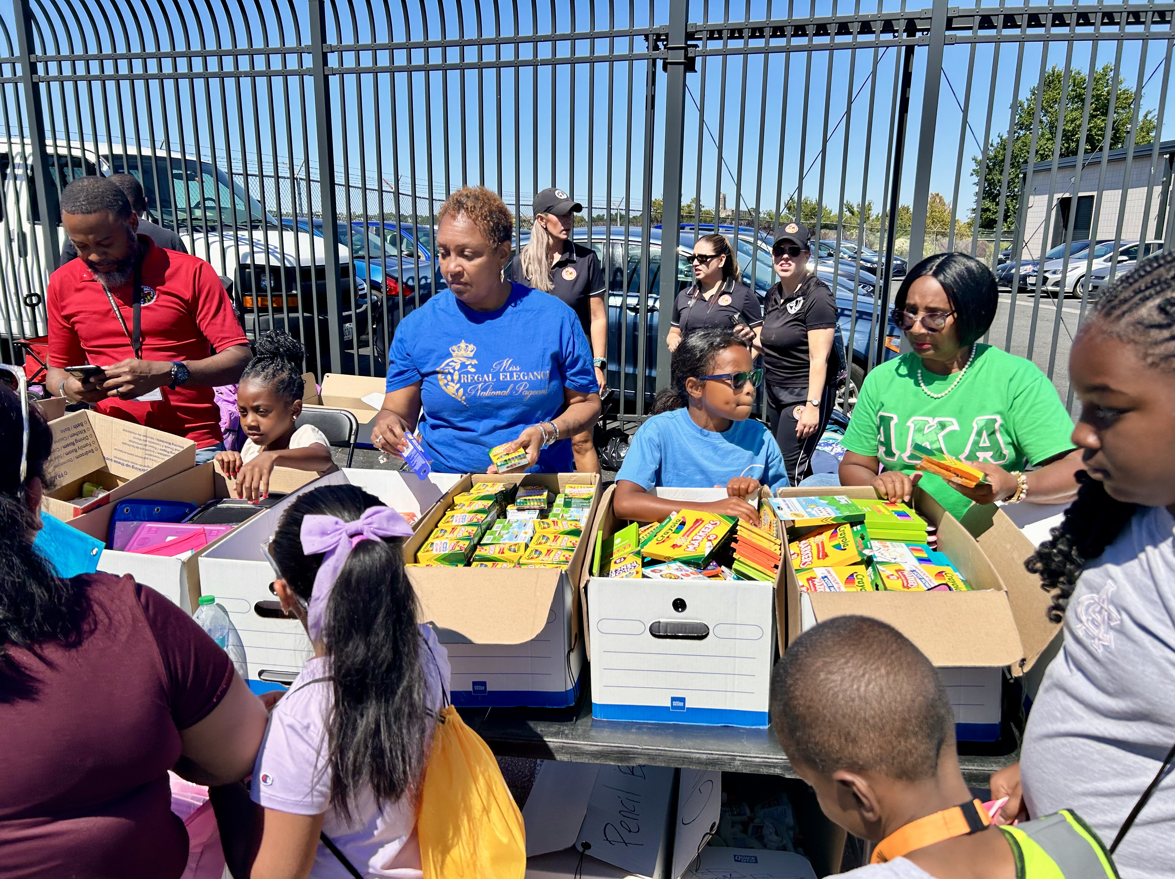 Back-to-school event attendees receive school supplies and educational materials.